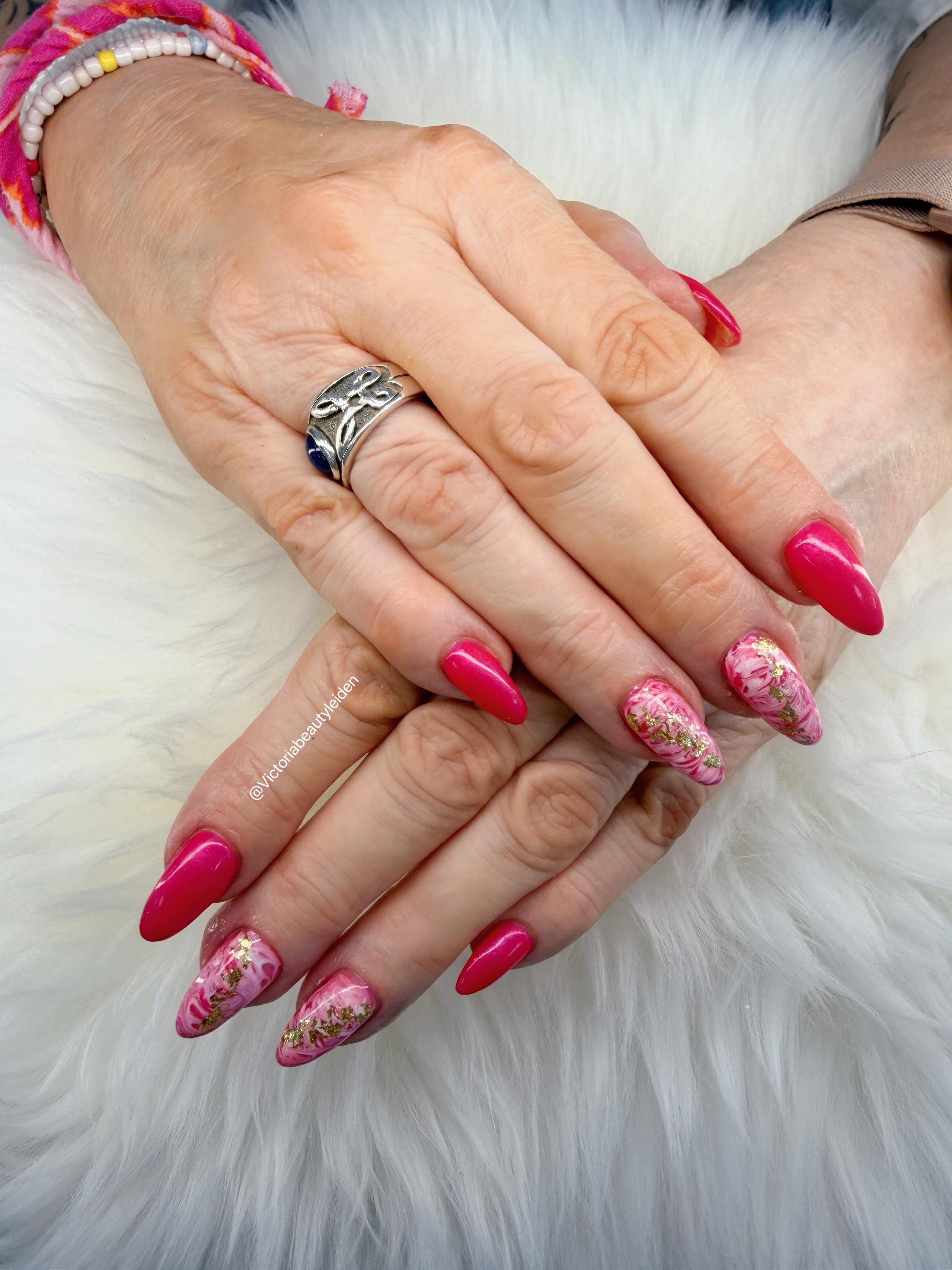 Felroze amandelnagels met marmer en goud nail art, handen op wit bont