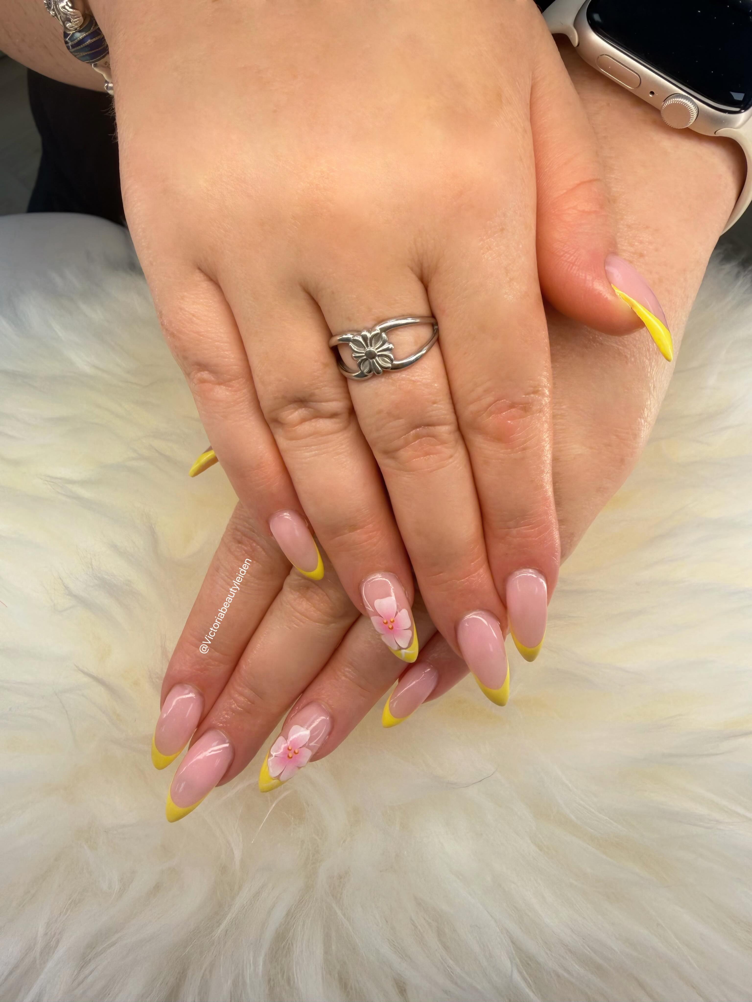 Zachte nude nagels met gele French tips en handgeschilderde bloemetjes
